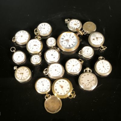 many different types of pocket watches on a black surface