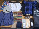 une table sur laquelle sont posés beaucoup de vêtements et de chaussures