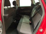 the back seat of a red car with a bottle of beer in it