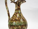 un vase marron et vert orné d'un oiseau