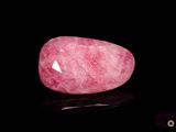 un quartz rose posé sur une surface noire