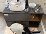 a white sink sitting on top of a black cabinet