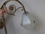 a woman standing next to a lamp that is on a table