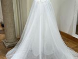 the wedding dress is displayed on a mannequin stand in the room