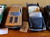 Plusieurs petites voitures sont alignées sur une table en bois