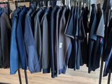 clothing racks in a clothing store with a variety of jackets hanging on them