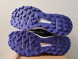 the soles of a pair of purple running shoes on top of a cardboard box