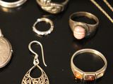 many different types of jewelry on a black surface