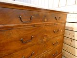 une commode en bois avec un plateau en marbre, placée dans un coin de la pièce