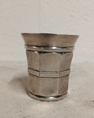 a silver cup that is sitting on a table