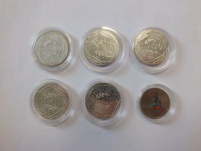 six different types of coins in plastic containers on a white surface