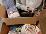 une boîte remplie de couches et d'autres articles pour bébé posée par terre