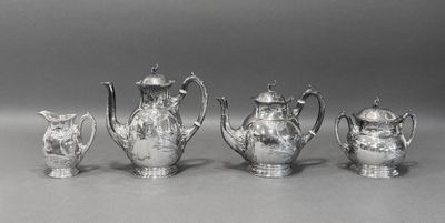 quatre théières en argent et une cafetière posées sur une table