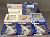 Plusieurs maquettes d'avions sont rangées dans des boîtes posées sur une table