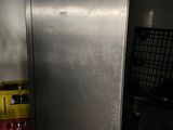 a stainless steel refrigerator in a room with boxes of beer