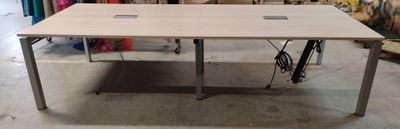 une table sur laquelle est posé un ordinateur portable, dans une pièce