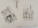two drawings of buildings are shown in a book on a table