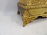 a gold clock sitting on top of a wooden table