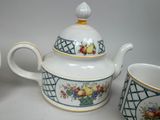three cups and a teapot sitting on a table