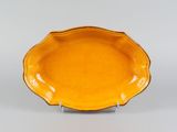 an orange plate on a metal stand on a white surface