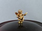 a gold figurine sitting on top of a black plate