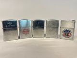 quatre briquets Zippo sont alignés sur une surface blanche