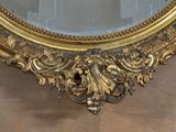 a mirror with a gold frame on the wall