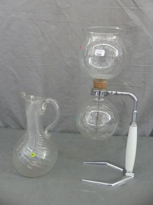 deux vases en verre et une bouteille munie d'une anse, posés sur une table