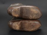 pair of brown leather shoes stacked on top of each other on a black surface
