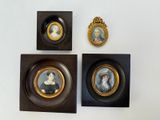 three framed portraits of women are displayed on a white wall