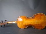 an old violin sitting on top of a table next to a black background