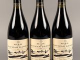 trois bouteilles de vin posées sur une table l'une à côté de l'autre