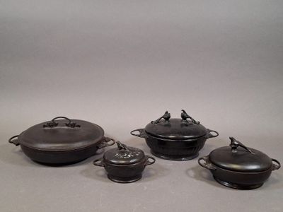 four pieces of cast iron pots and pans sitting on a table