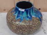 un vase bleu et marron posé sur une table