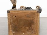 a wooden box with a statue of a person inside of it