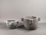 two cement pots sitting next to each other on a table