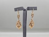 une paire de boucles d'oreilles plaquées or sur un présentoir