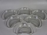 six clear glass bowls are arranged in a heart shape on a white surface