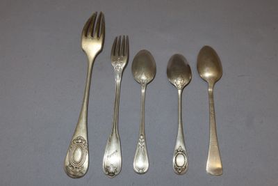 four silver spoons and a fork are lined up on a table