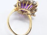 an image of a gold ring with an amethorate and diamonds