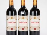 trois bouteilles de vin rouge posées sur une table