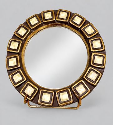 a close up of a mirror on a stand on a gray surface