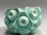 a green bowl with a large eyeball inside of it