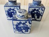 three blue and white vases sitting on a table