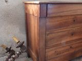a wooden chest of drawers in the corner of a room