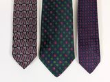 three ties are lined up on a white surface
