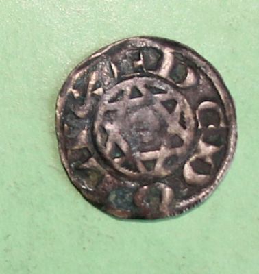 a silver coin with a star on it on a green surface