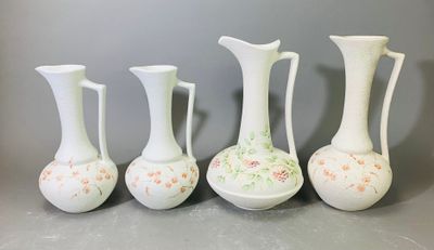 quatre vases blancs posés les uns à côté des autres sur une table