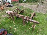 a tractor plow sitting on the grass in the yard