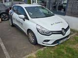 une voiture blanche garée dans un parking à côté d'un bâtiment